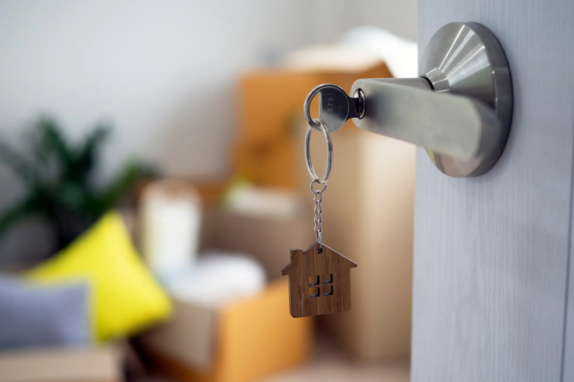 Key with house-shaped keychain in door lock, representing property compliance for landlords in Aberdeen